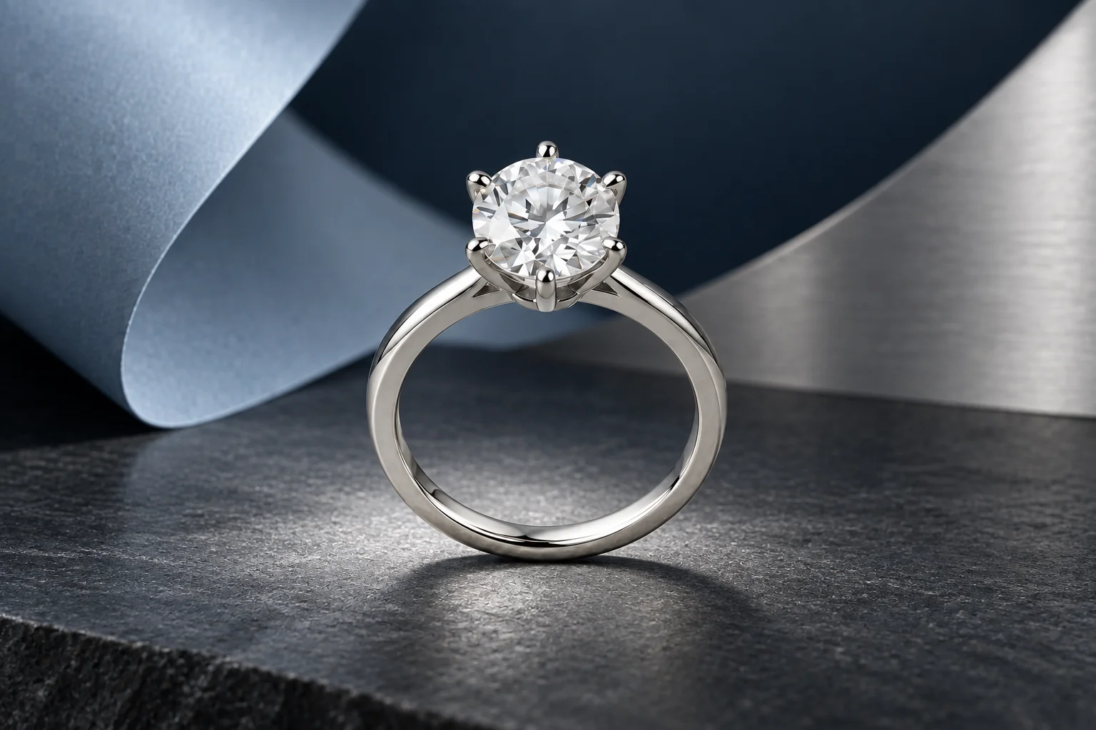 A platinum solitaire on dark stone with pale blue and silver sculptural panels